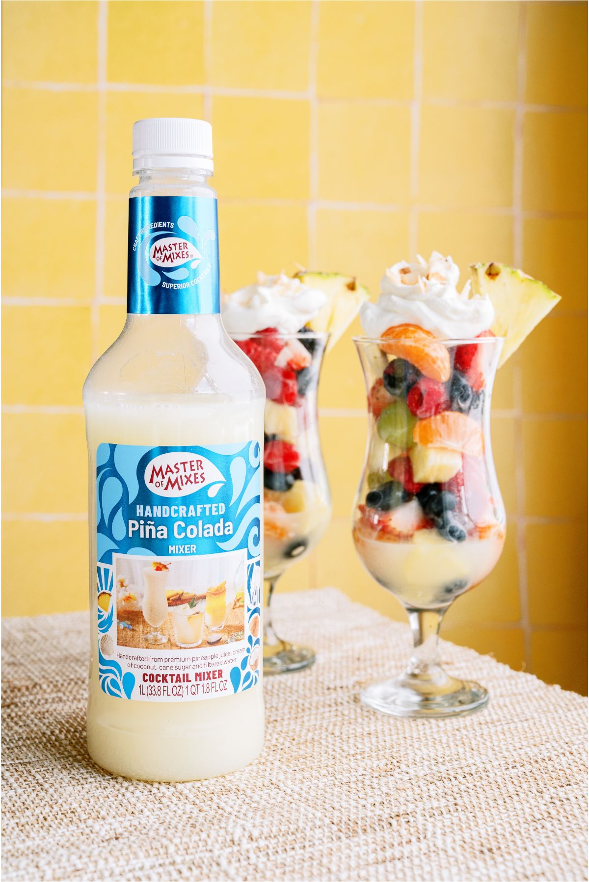 2 glasses with Pina Colada Fruit Salad and Non alcoholic pina colada mixer in a bottle 