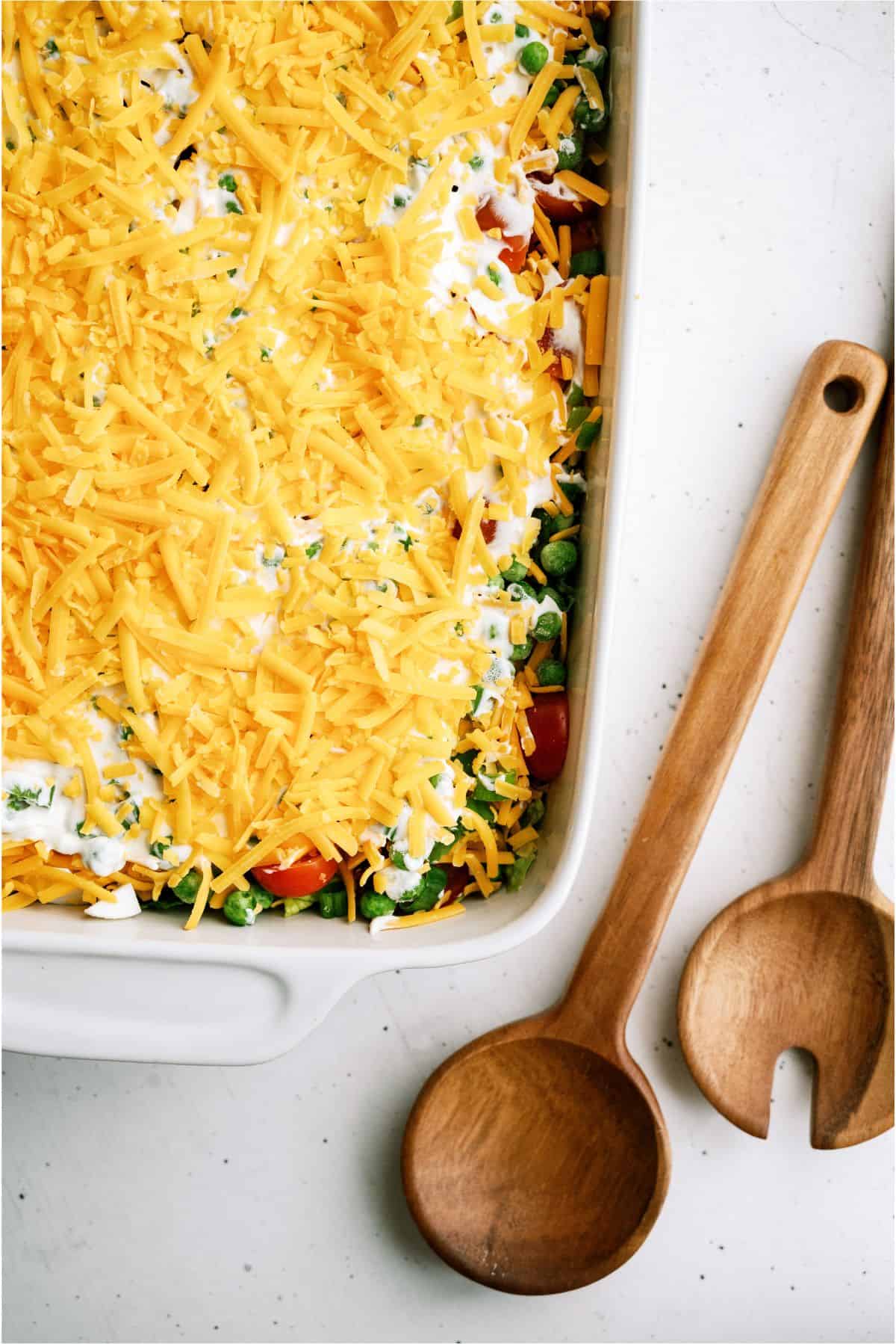 Shredded cheddar cheese as the top layer of the Seven Layer Green Salad