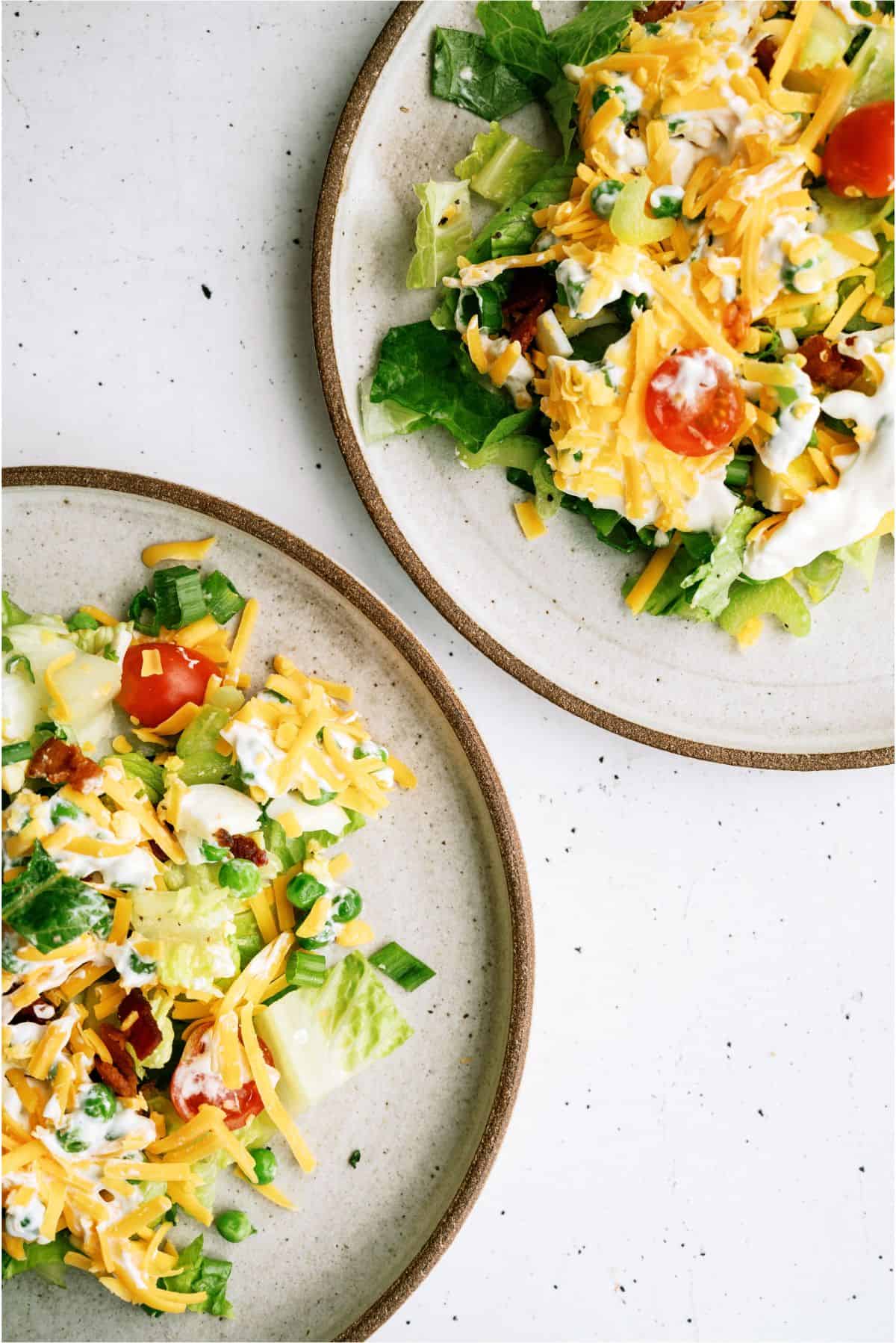 2 plates with servings of Seven Layer Green Salad