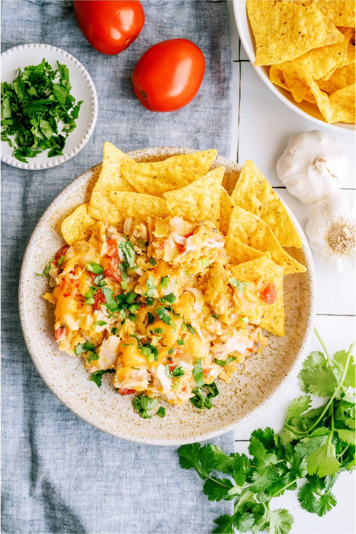 A serving of Slow Cooker King Ranch Chicken on a plate with extra tortilla chips