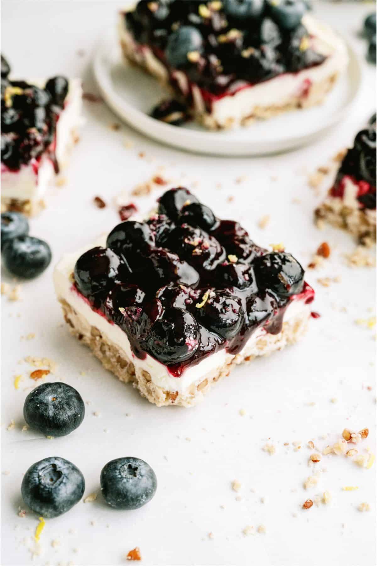 A slice of Blueberry Jamboree on the counter with fresh blueberries