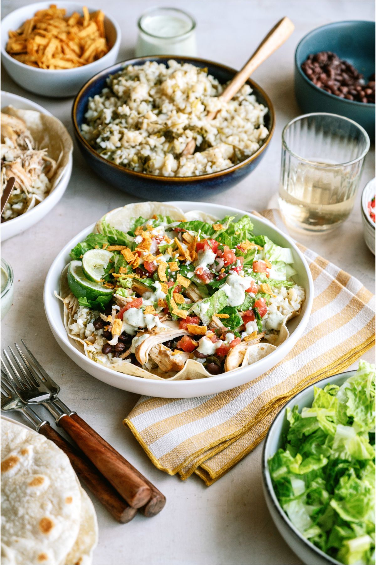 Cafe Rio Slow Cooker Chicken and Cilantro Rice in a bowl with toppings surrounded by toppings