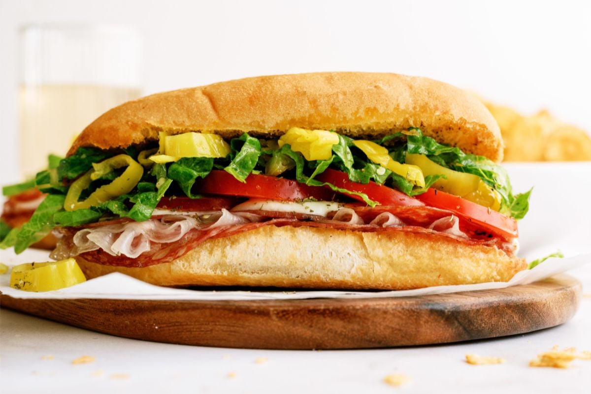 Side view of a Hot Italian Trio Sandwich on a cutting board