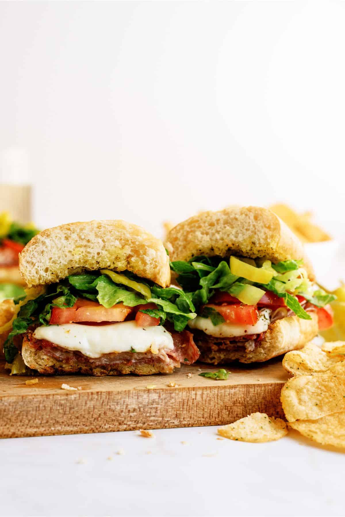 A Hot Italian Trio Sandwich cut in half on a cutting board