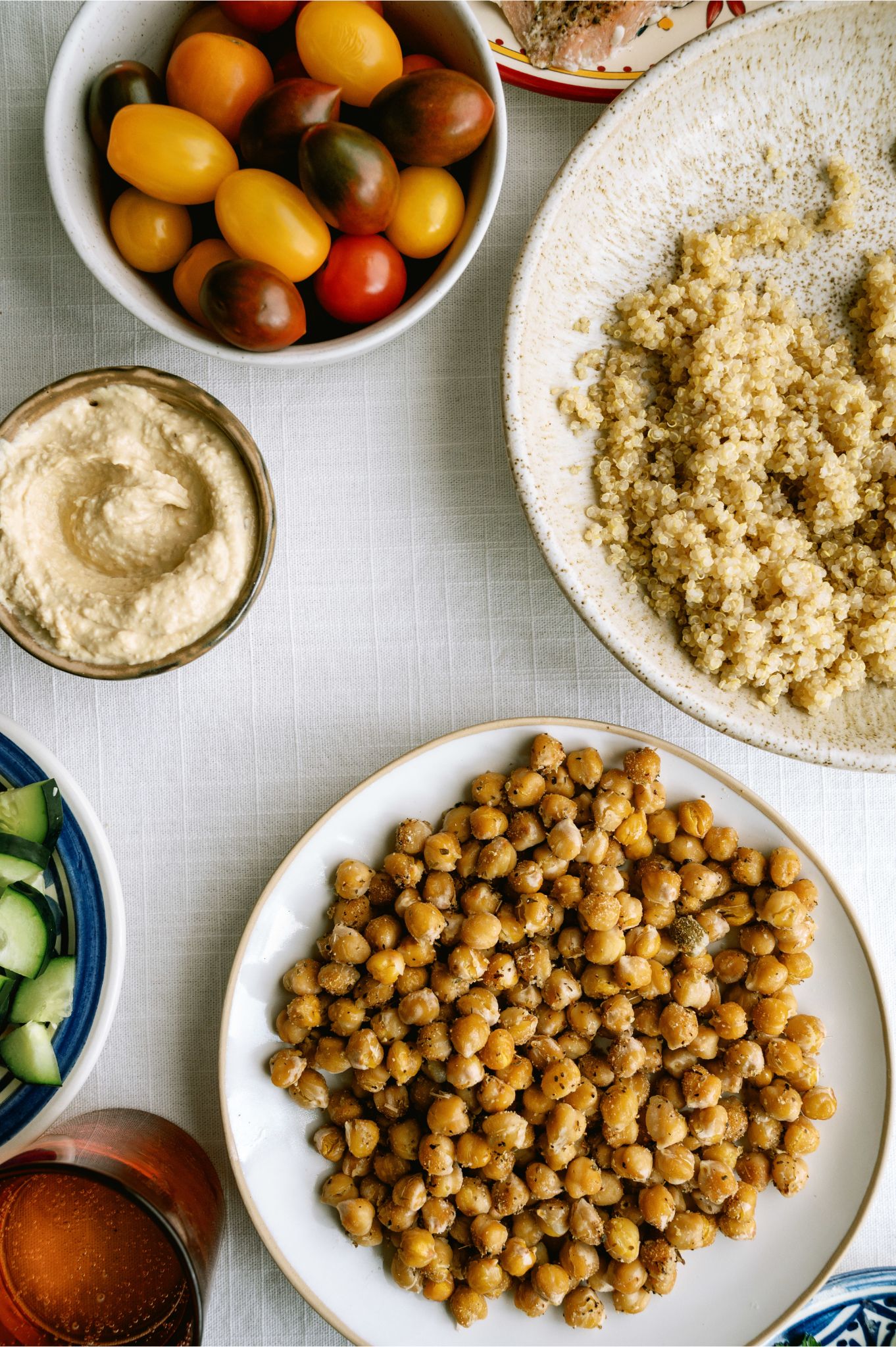A bowl of quinoa, a bowl of tomatoes and a bowl of toasted chickpeas