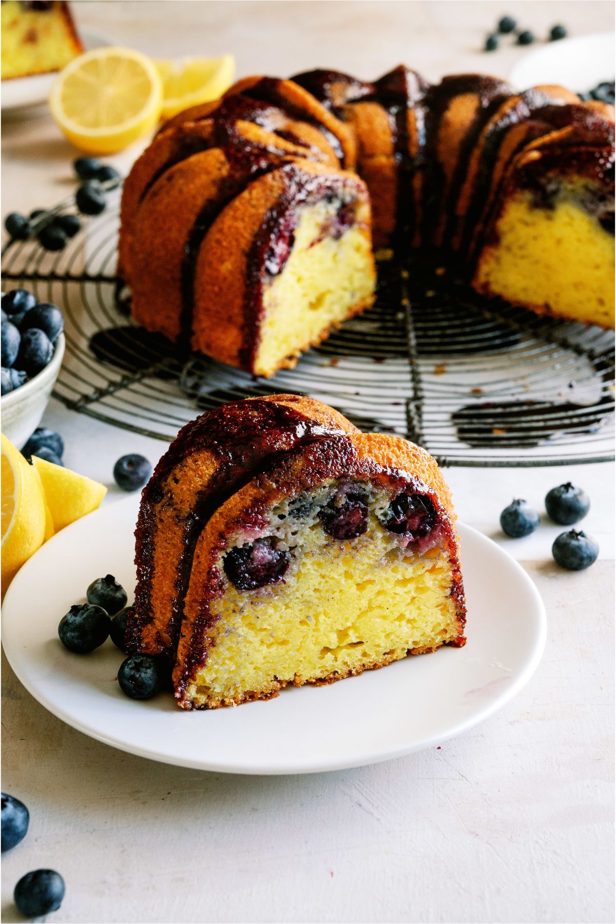 Lemon Blueberry Bundt Cake with one slice on a plate