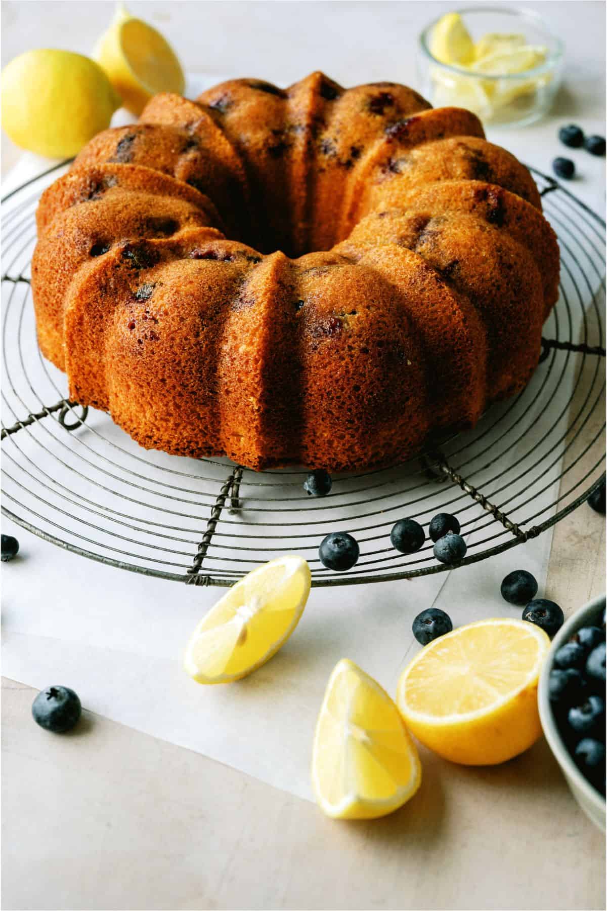 Lemon Blueberry Bundt Cake without the bueberry glaze. Surrounded by blueberries and lemon wedges