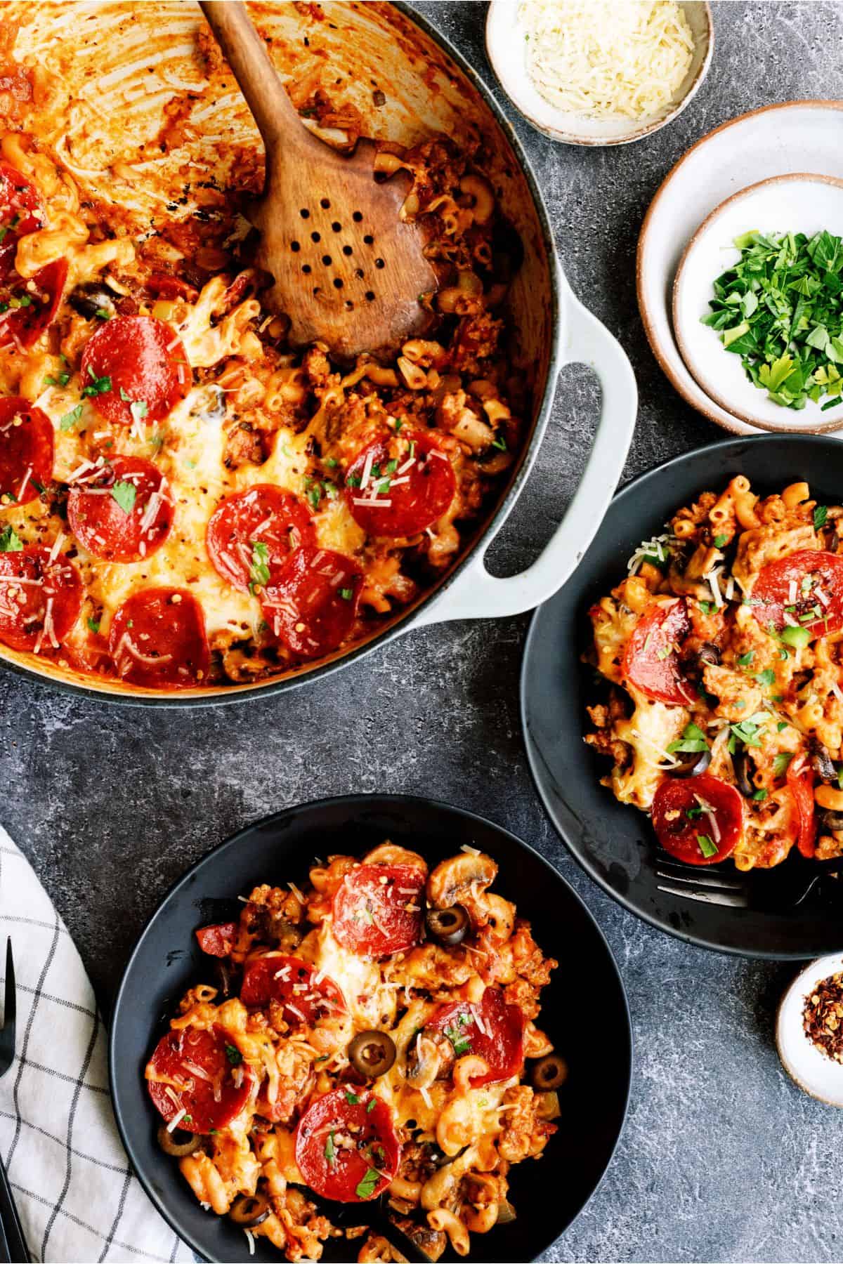 Top view of Pizza Skillet Pasta in the skillet with two servings in bowl