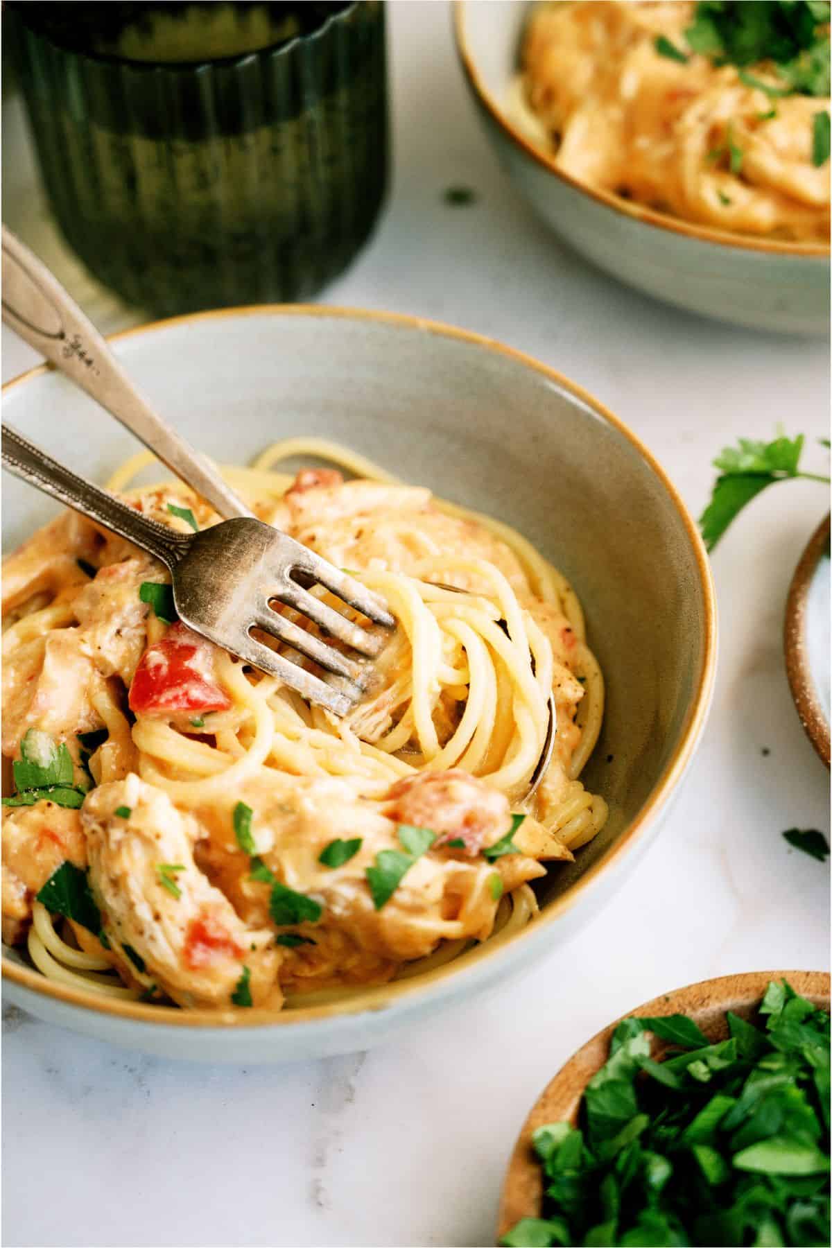 A bowl of Slow Cooker Chicken Spaghetti and 2 forks