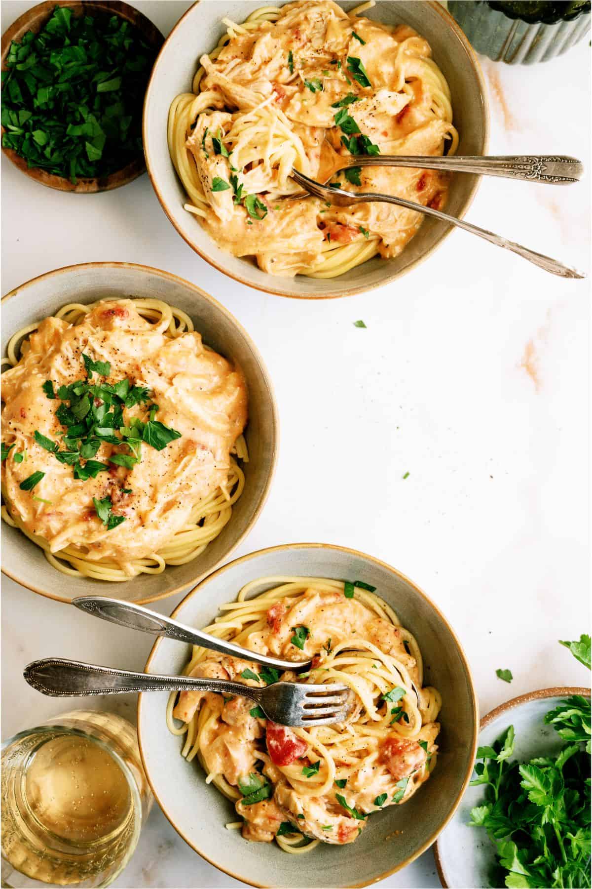 3 bowls of Slow Cooker Chicken Spaghetti with fresh parsley on top