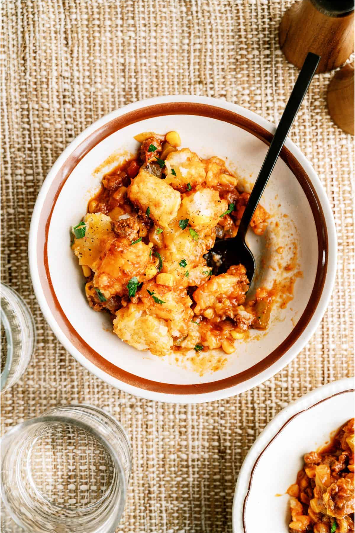 A serving of BBQ Tater Tot Casserole in a bowl with a fork