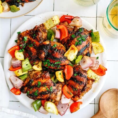 Top view of a plate of Grilled Boneless Chicken Thighs and grilled veggies