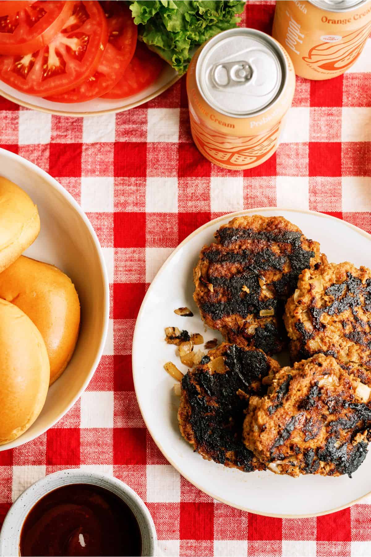Juicy BBQ Turkey Patties on a plate with toppings on another plate.