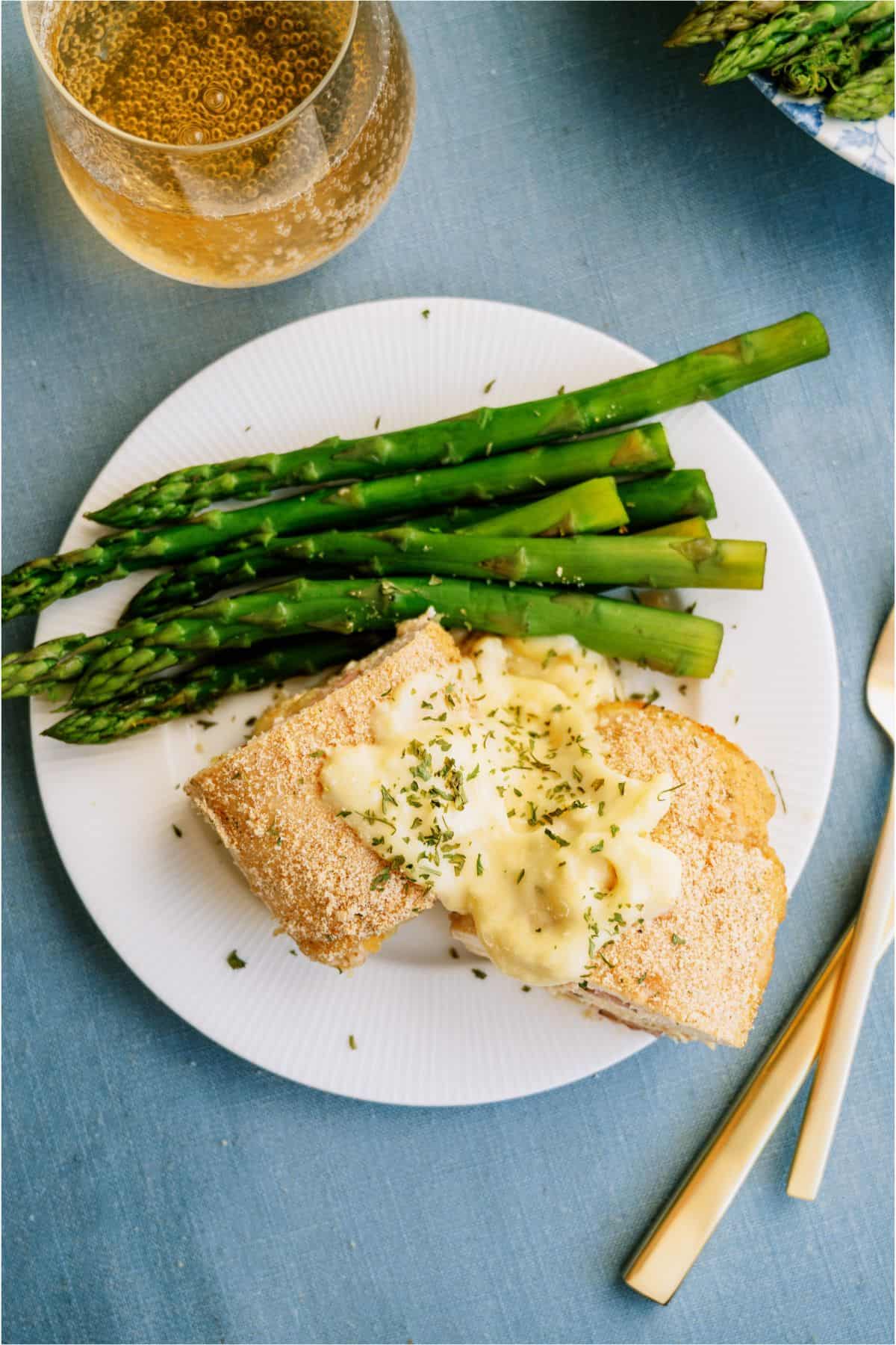 A plate with Malibu Stuffed Chicken and asparagus