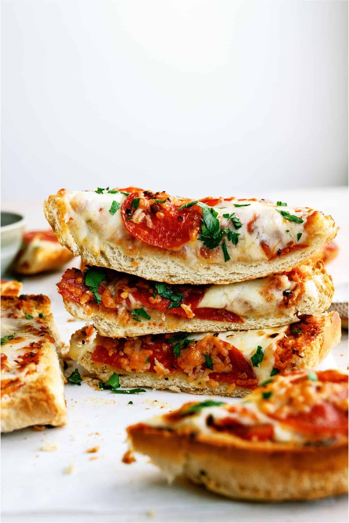 Slices of Air Fryer French Bread Pizza stacked on top of each other