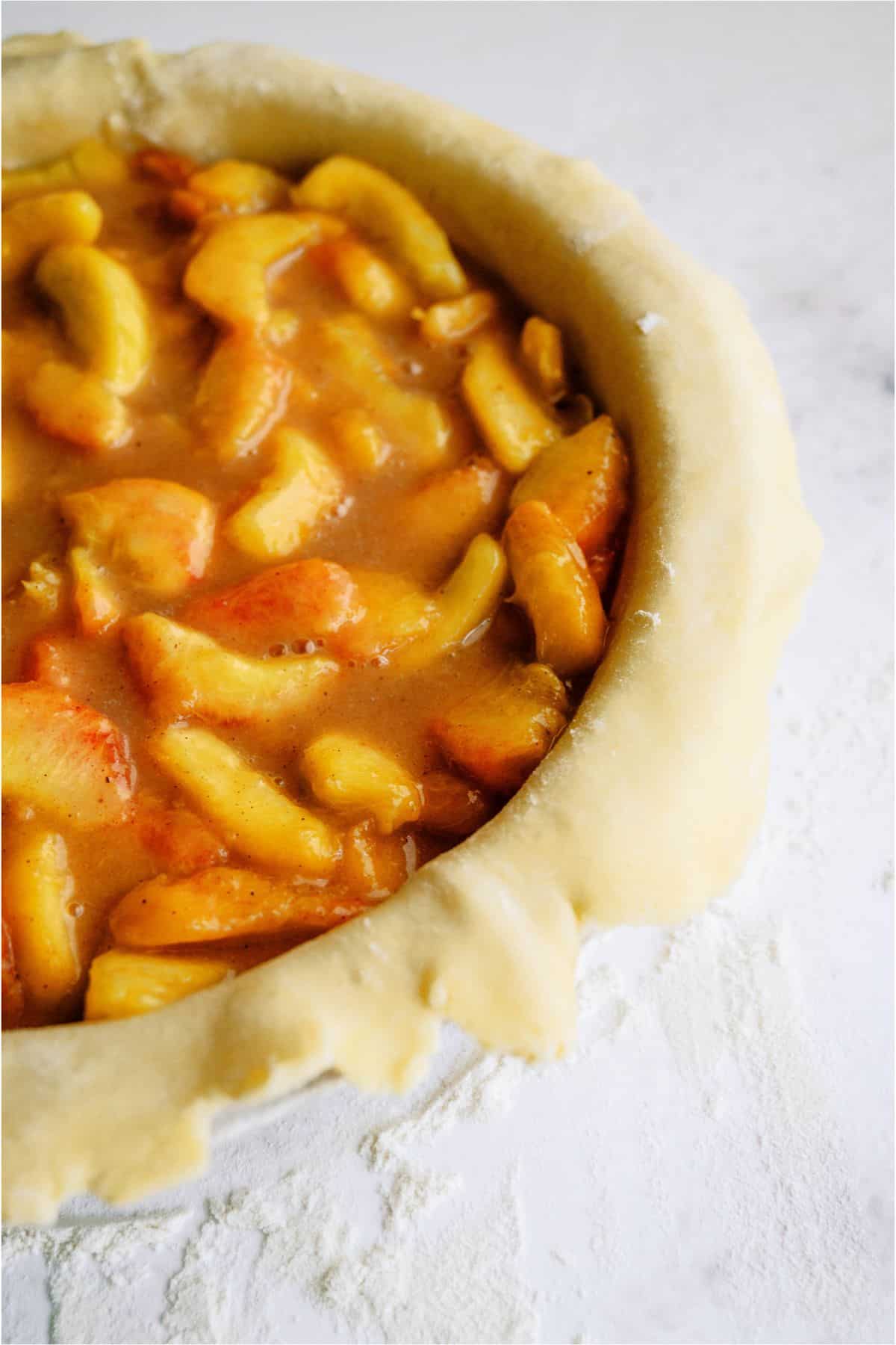 Peach filling poured into pie pan on top of crust.