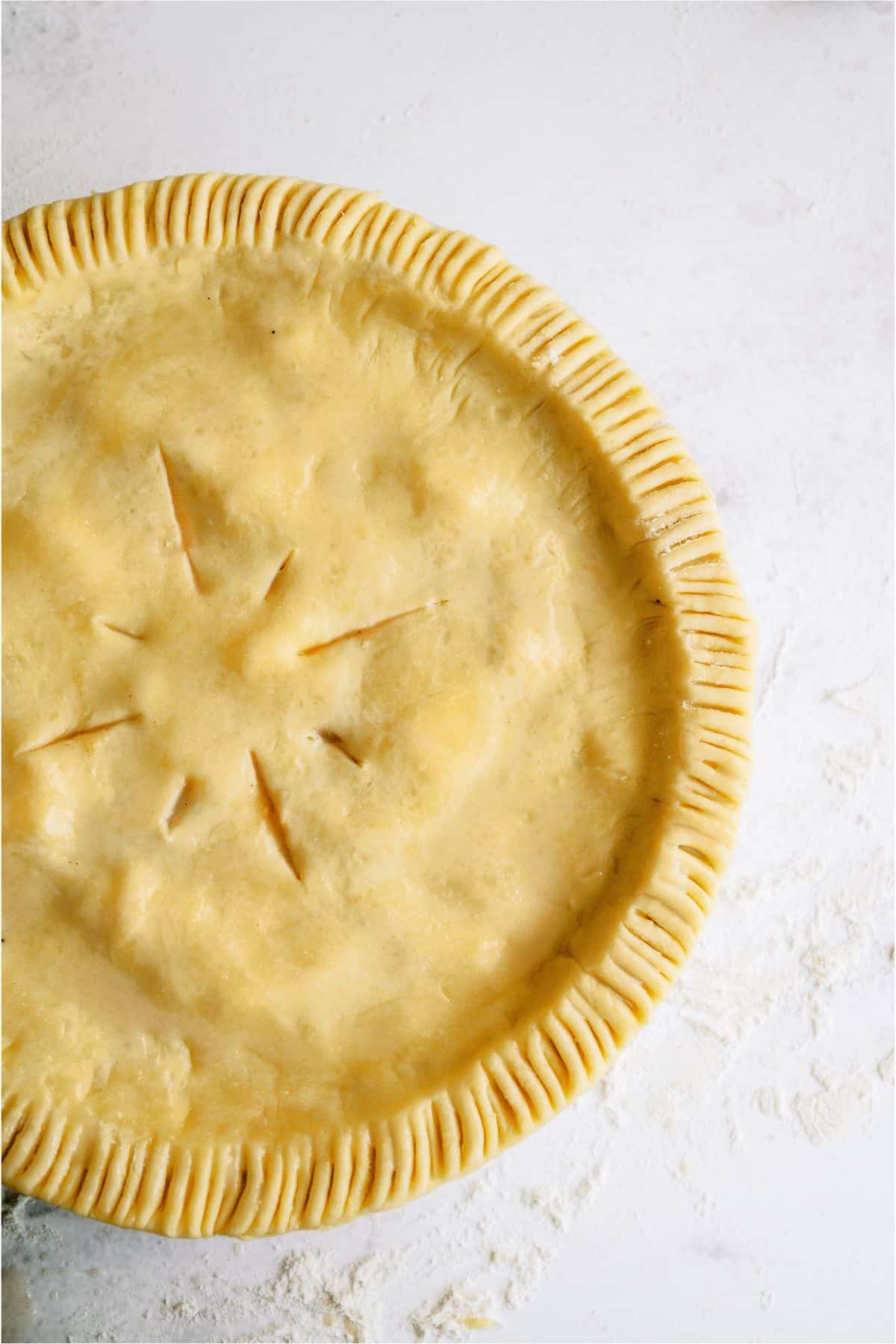 Top crust put on pie, crimped around the edges with a few slits in the top.