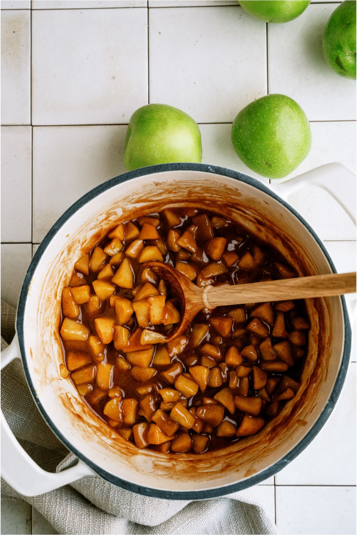Top view of large saucepan with Apple Pie Filling with a wooden spoon.