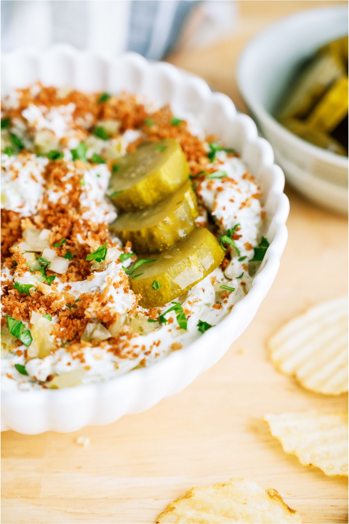 Close up view of a bowl of Fried Pickle Dip topped with pickles.