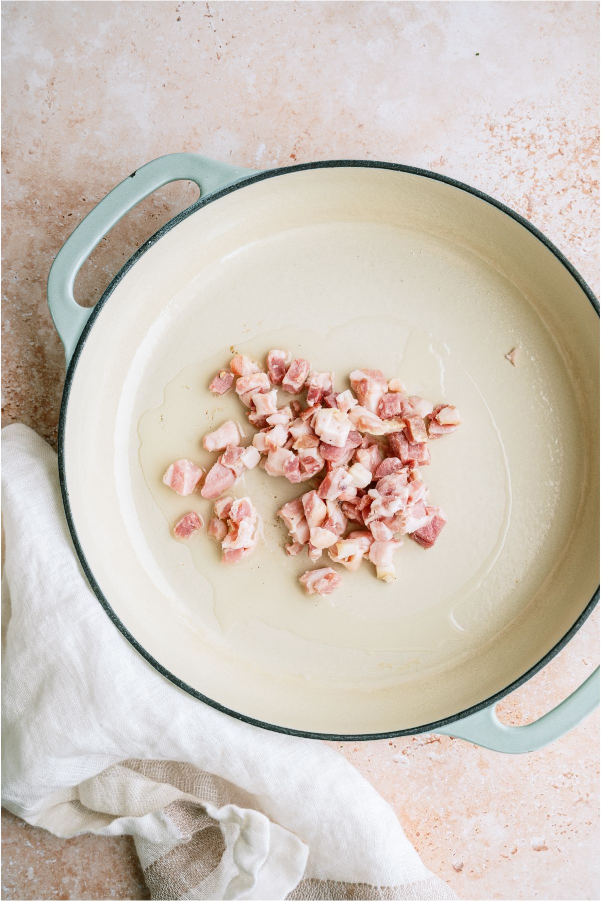 Raw pancetta chopped in a large pan.