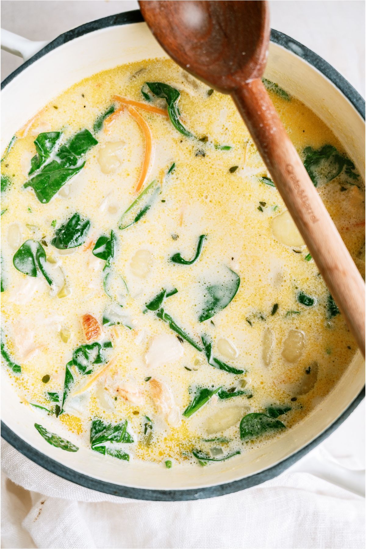 Creamy Chicken Gnocchi Soup in a stock pot with a wooden spoon.