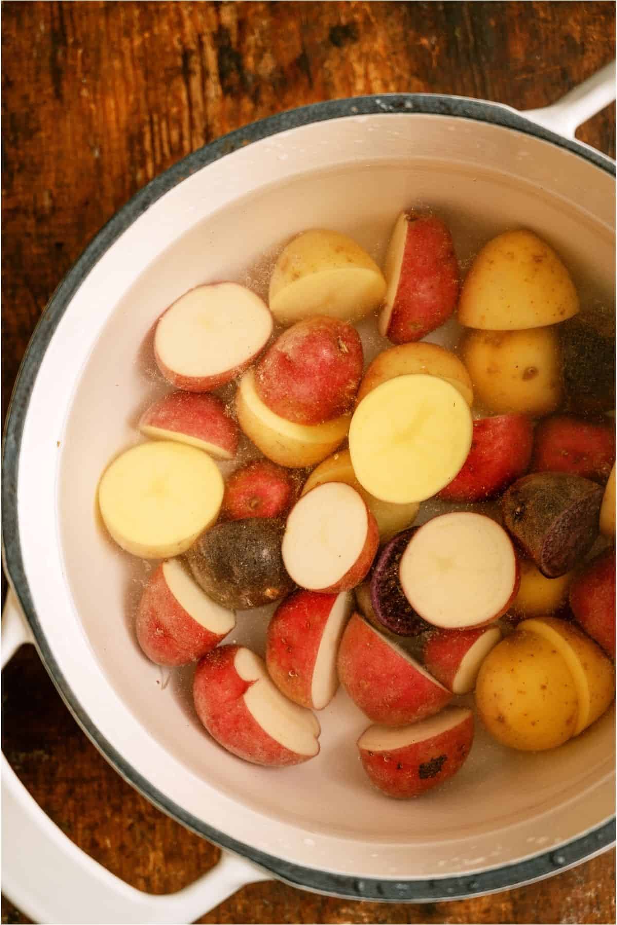 A pot of water with potatoes in it.