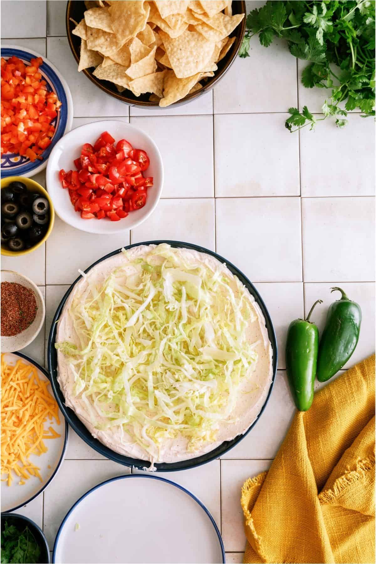 Shredded lettuce on top of the sour cream layer.