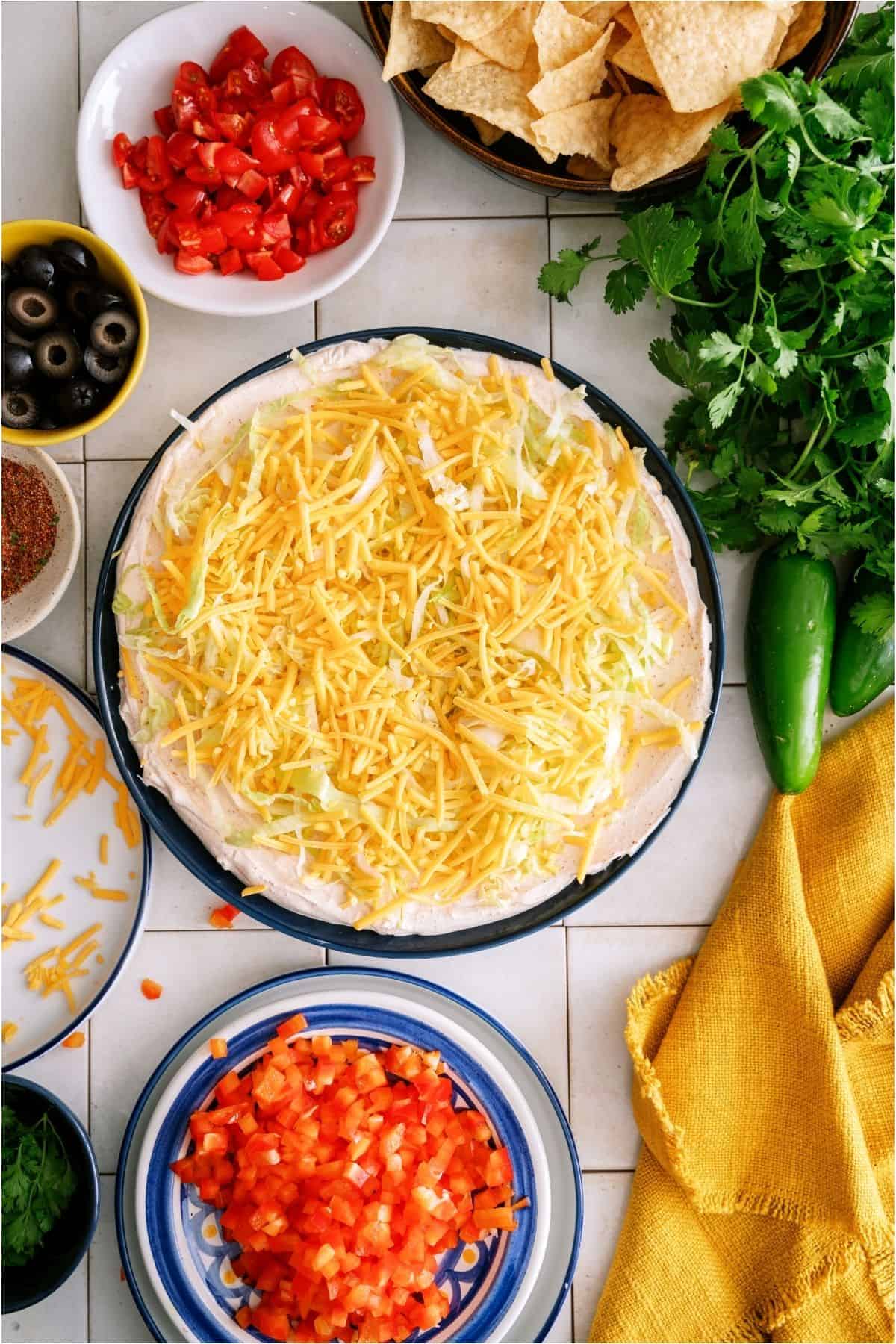 Shredded cheese on top of lettuce layer of taco dip.