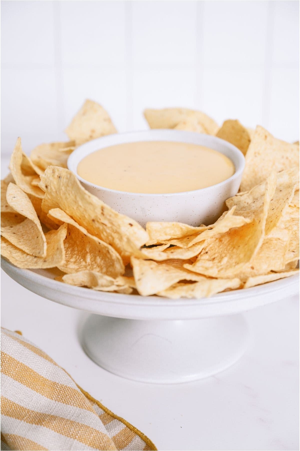 Quick Nacho Cheese Sauce in a bowl surrounded by tortilla chips.