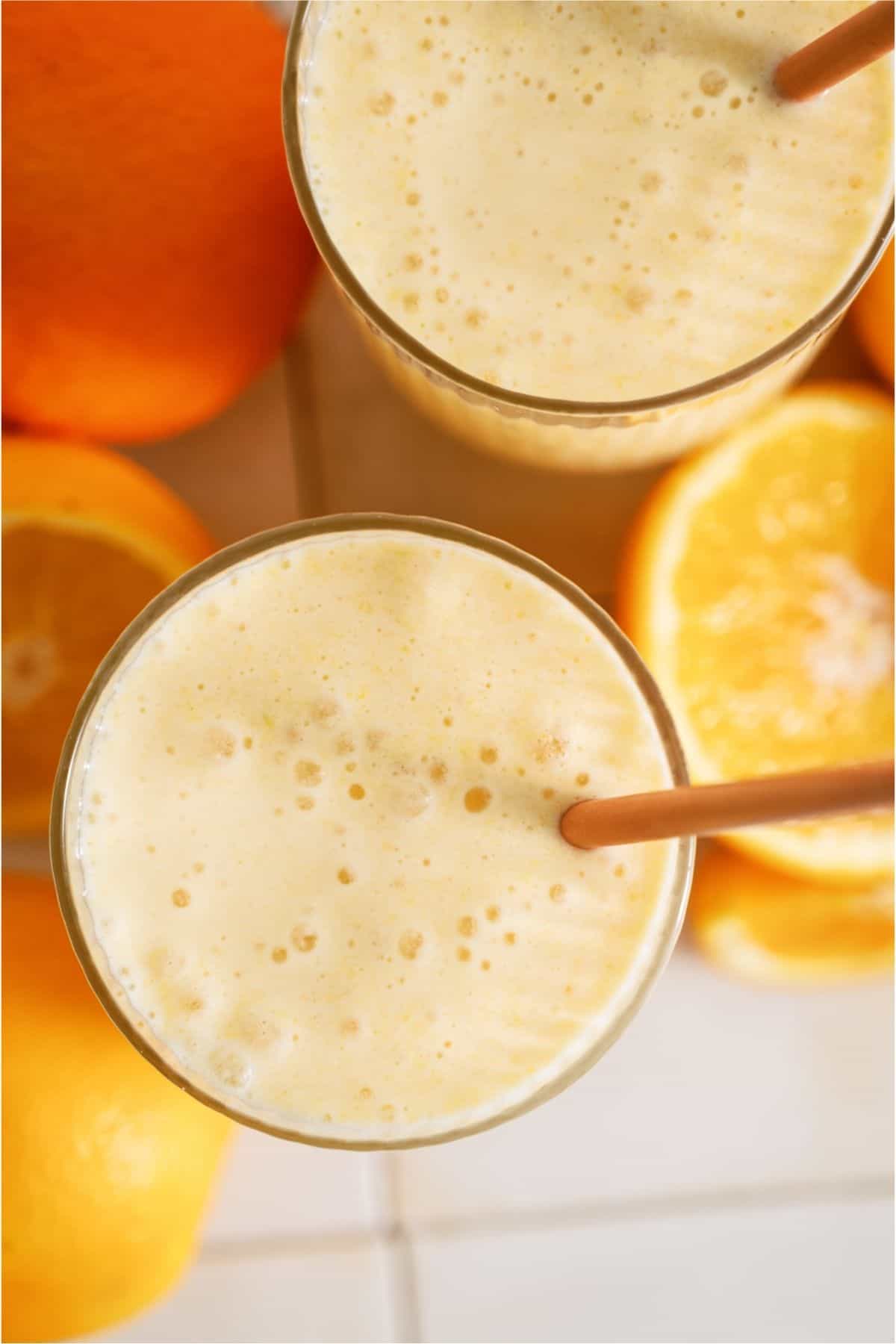 Top view of two cups of Copycat Orange Julius with straws.