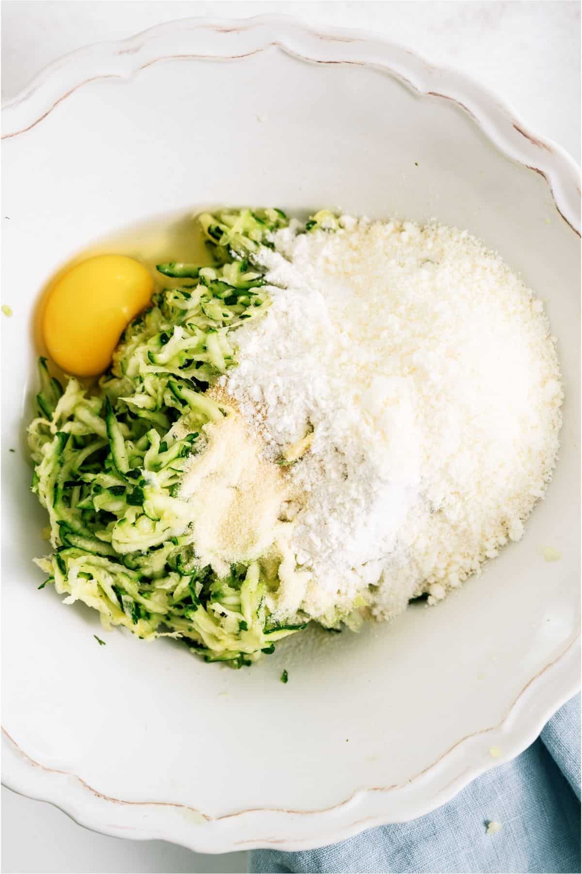 Ingredients for Crispy Zucchini Fritters added to a mixing bowl.