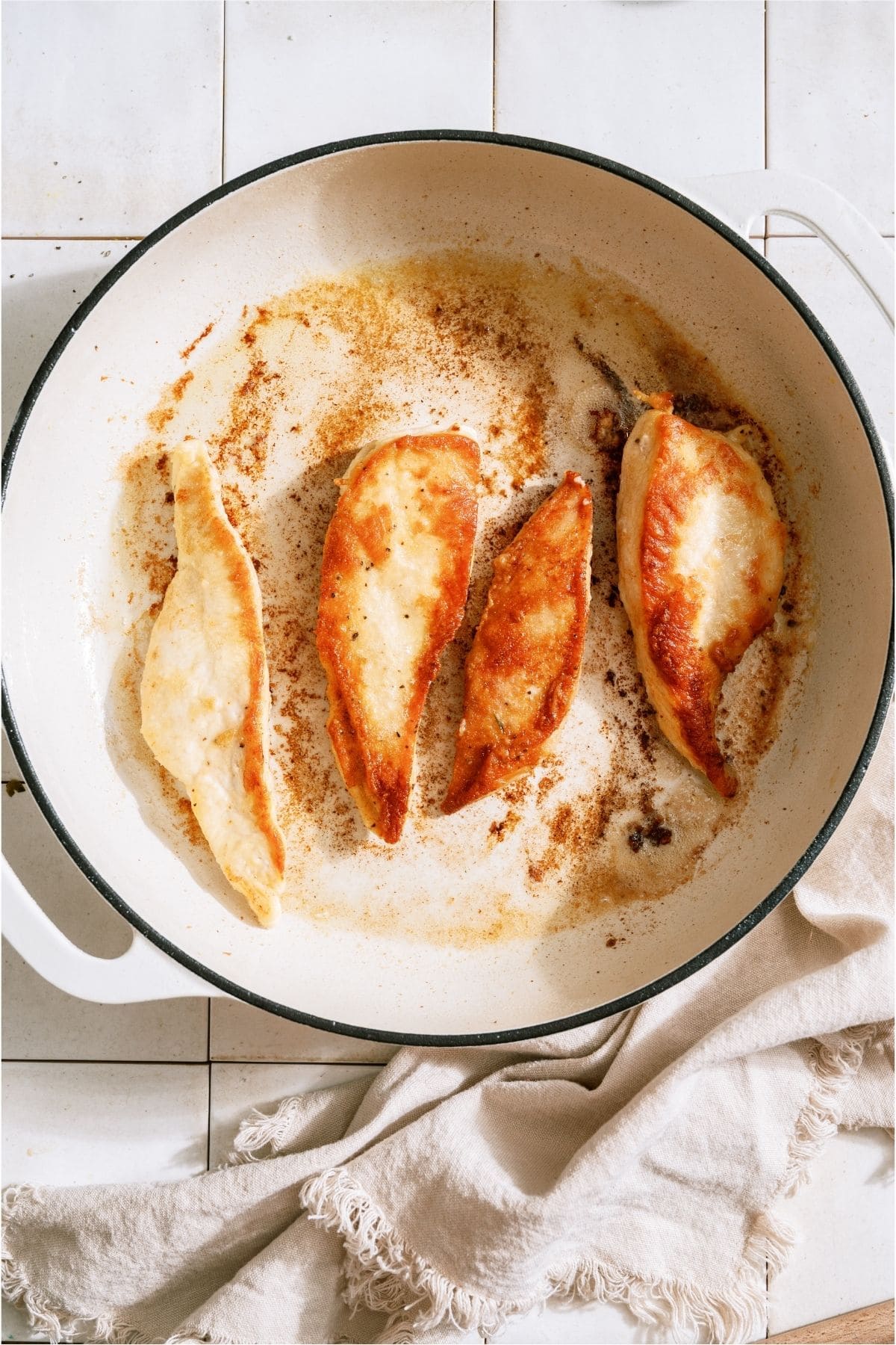 Browned chicken sections in a skillet.
