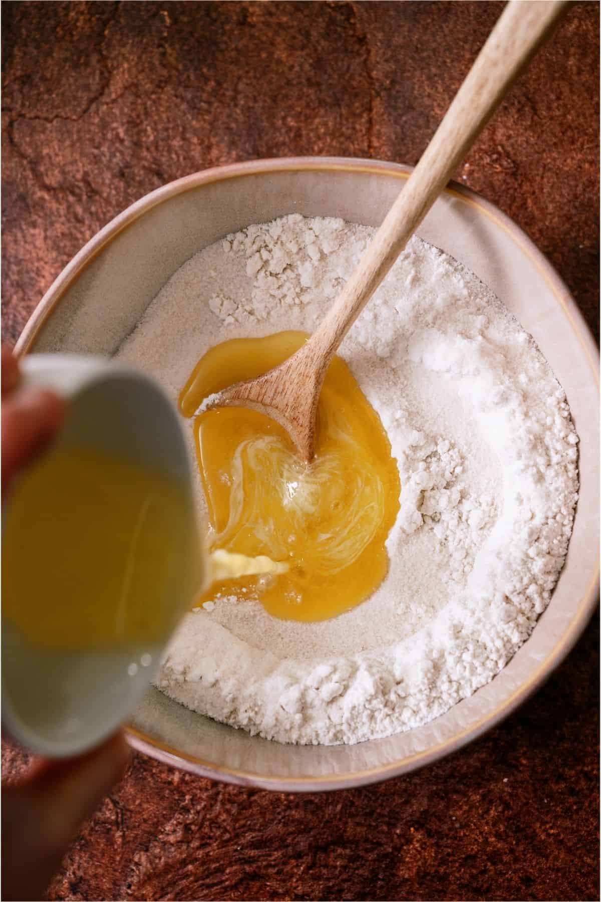 Melted butter poured into a bowl with flour.
