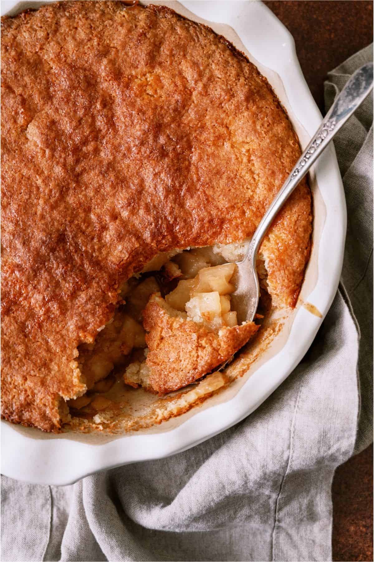 A spoon in the Easy Apple Cobbler dish showing the inside of the cobbler.