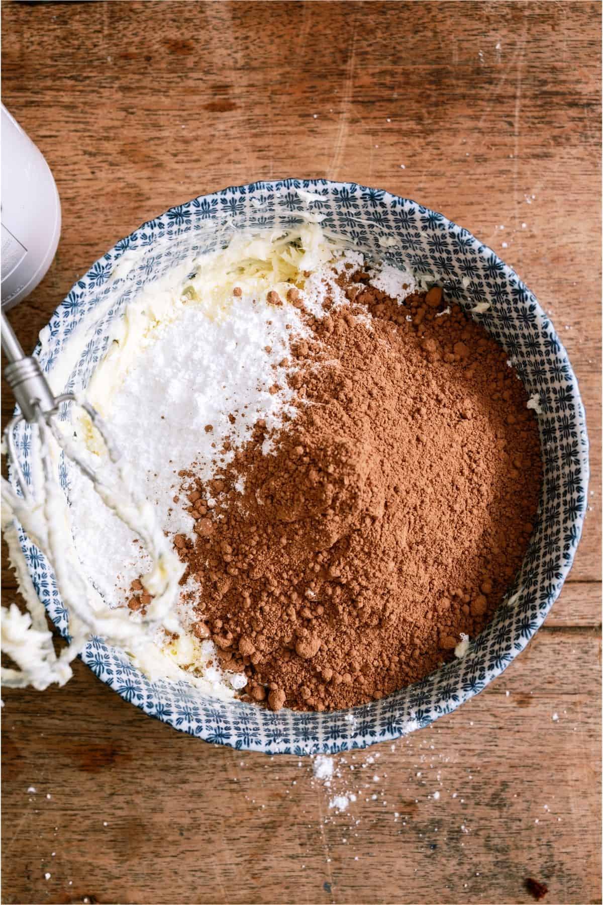 Ingredients for chocolate buttercream frosting in bowl.