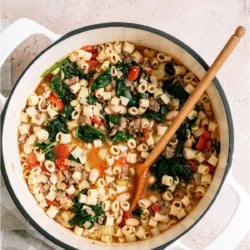 A pot of Pasta Fagioli soup with a wooden spoon.