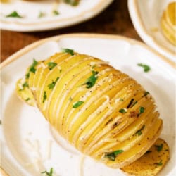 Crispy Hasselback Potatoes on white plates.