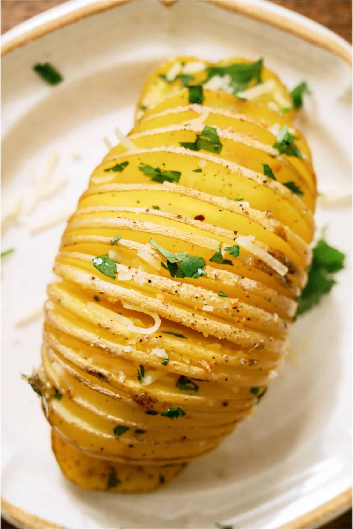 Top view of a Crispy Hasselback Potato on a white plate.