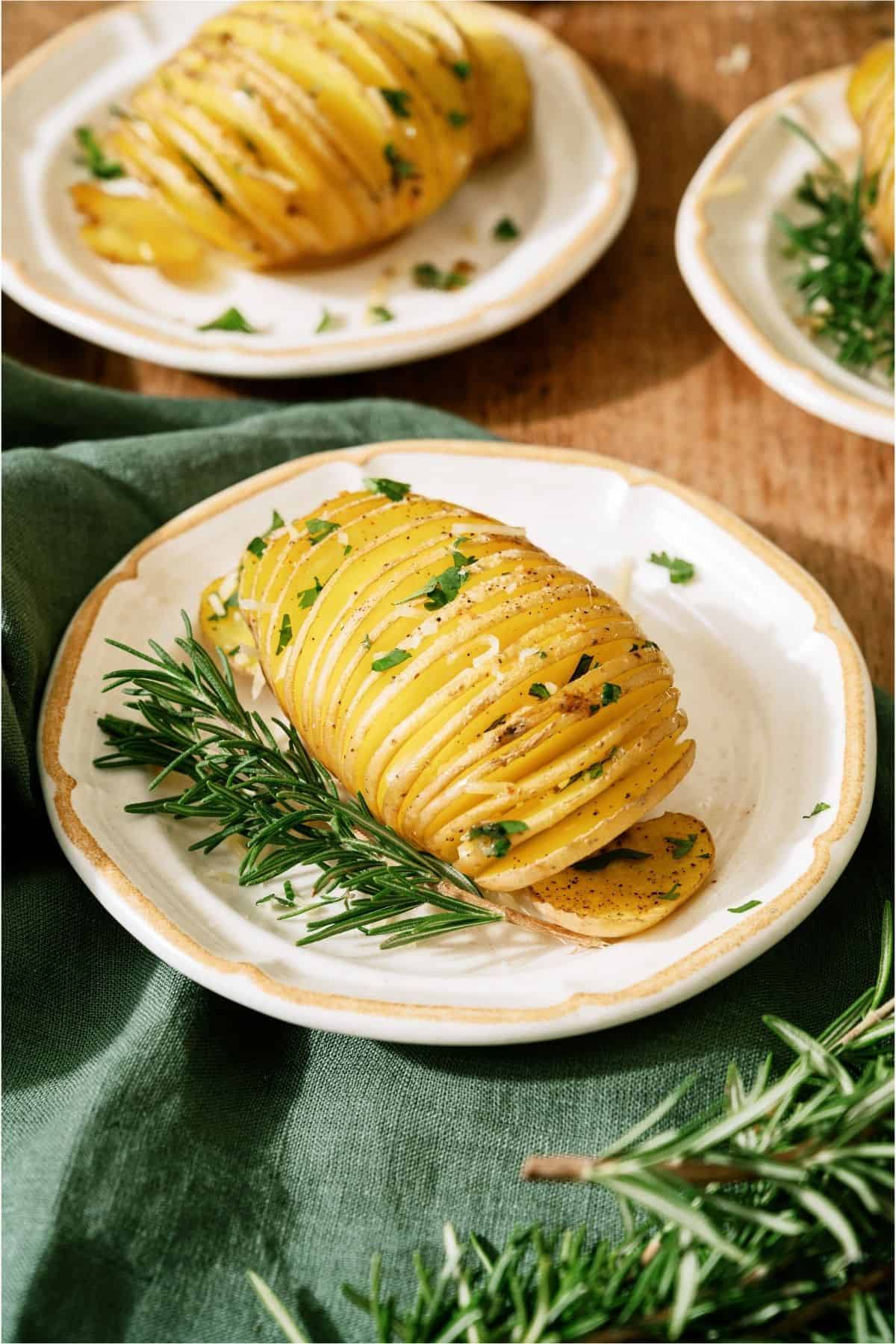 3 Crispy Hasselback Potatoes on white plates.