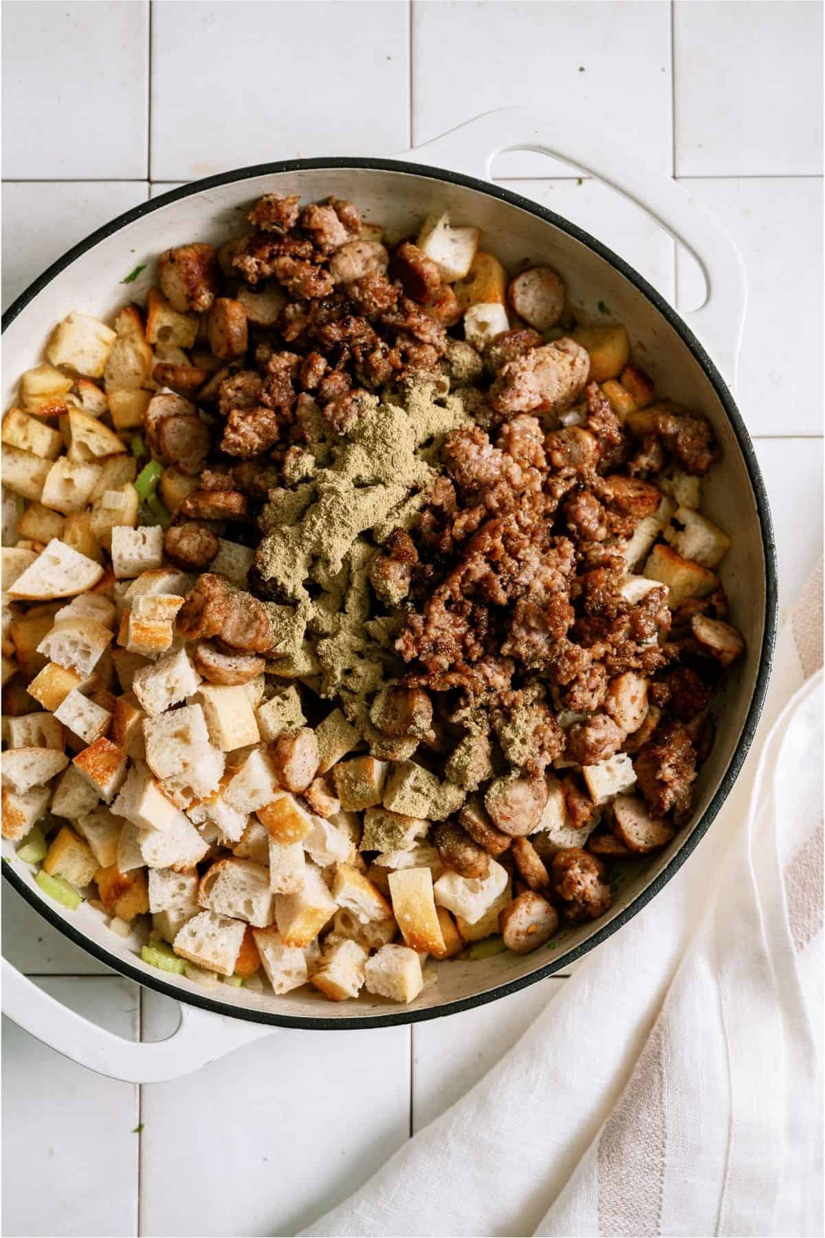 Adding cooked sausage on top of bread in skillet.