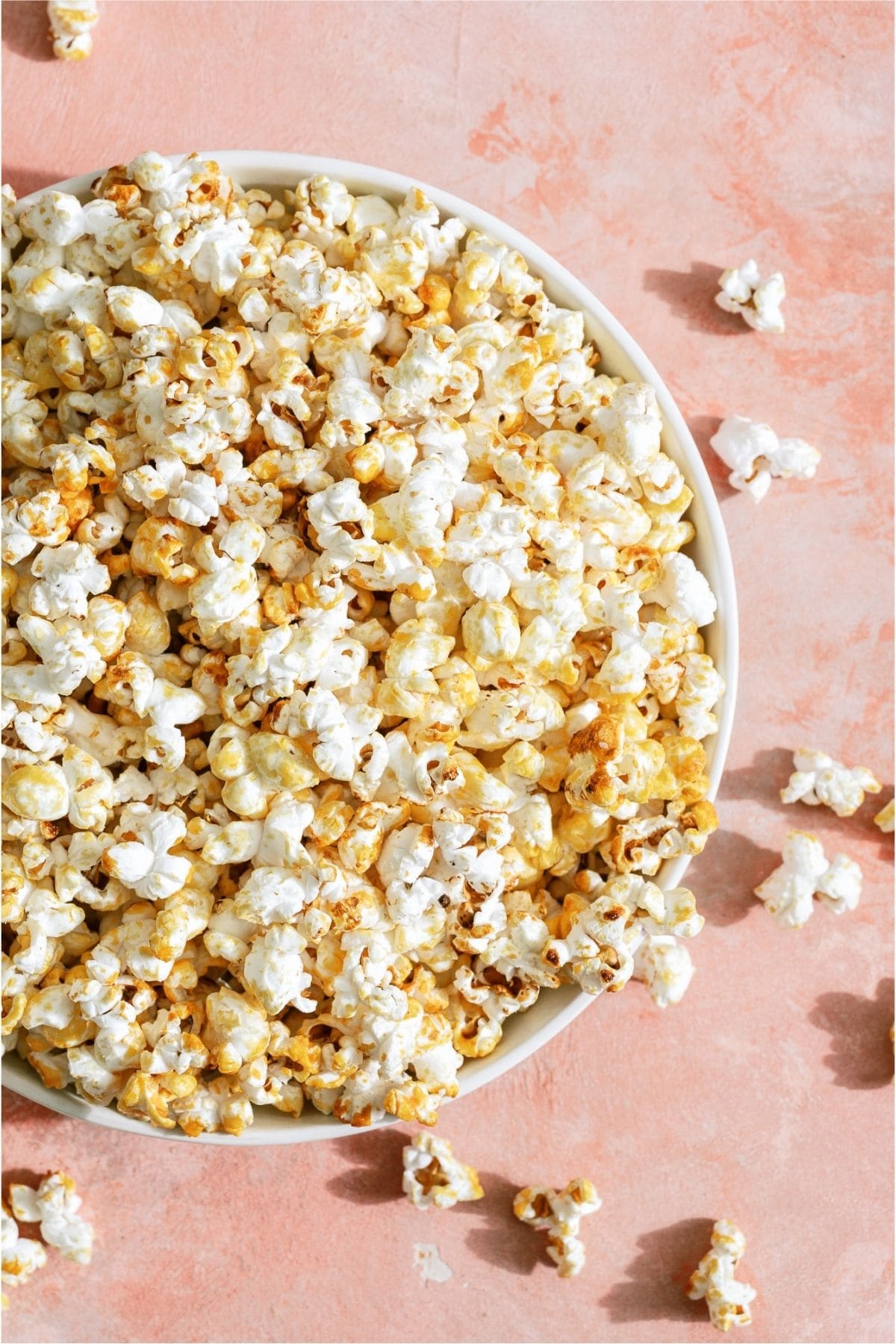 A large bowl of Easy Homemade Kettle Corn on a pink background.