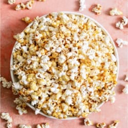 Top view of a bowl of Easy Homemade Kettle Corn on a pink background.