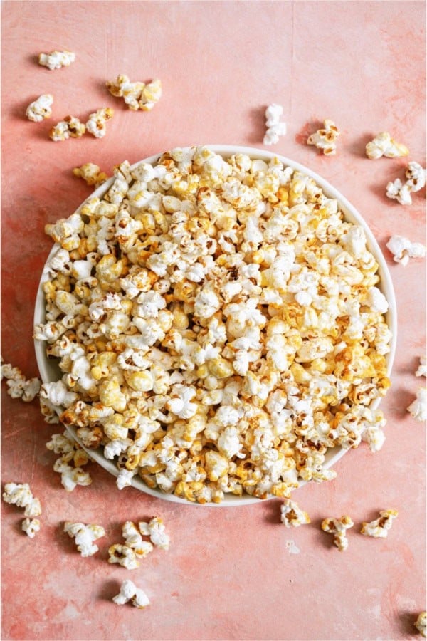 Top view of a bowl of Easy Homemade Kettle Corn on a pink background.