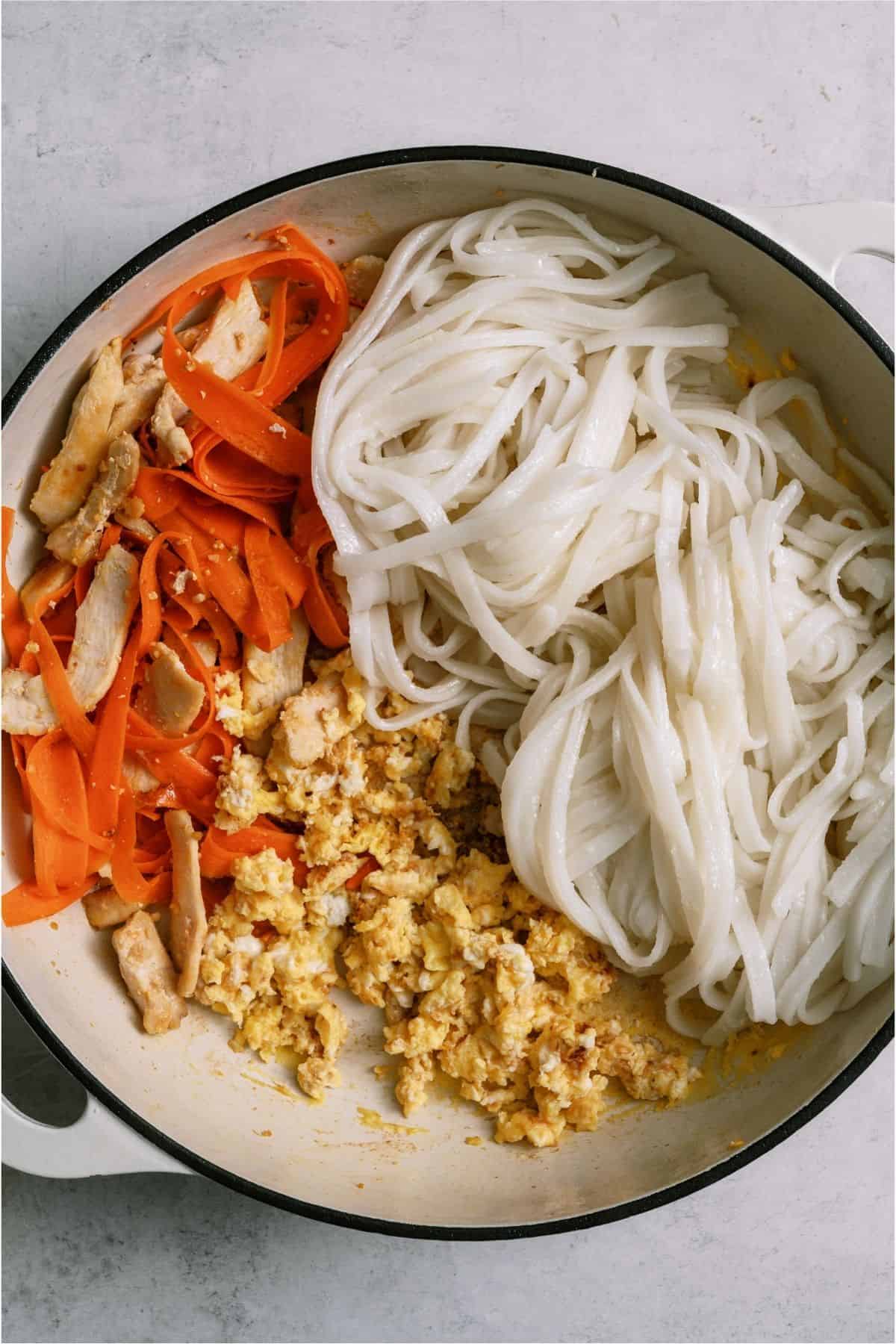 Chicken carrots and noodles in a large skillet.