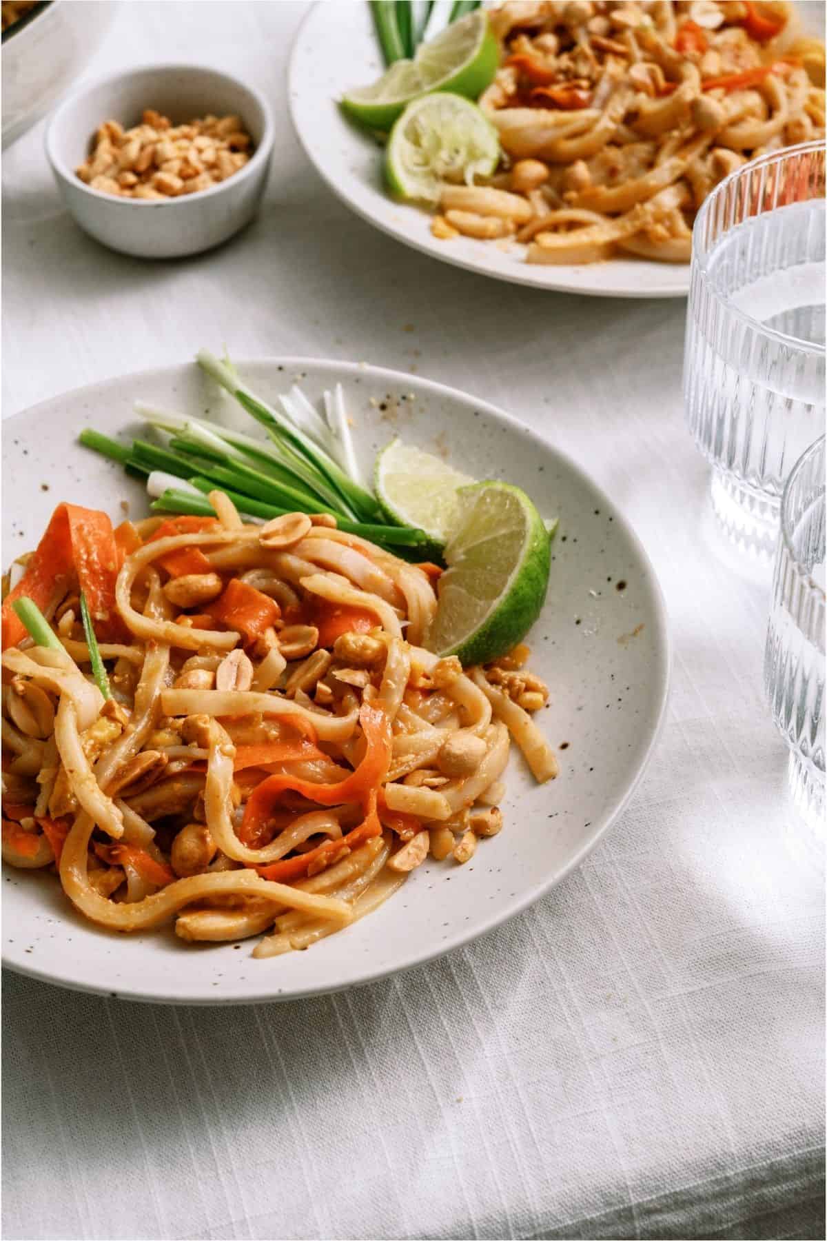 Two white plates with servings of Easy Pad Thai.