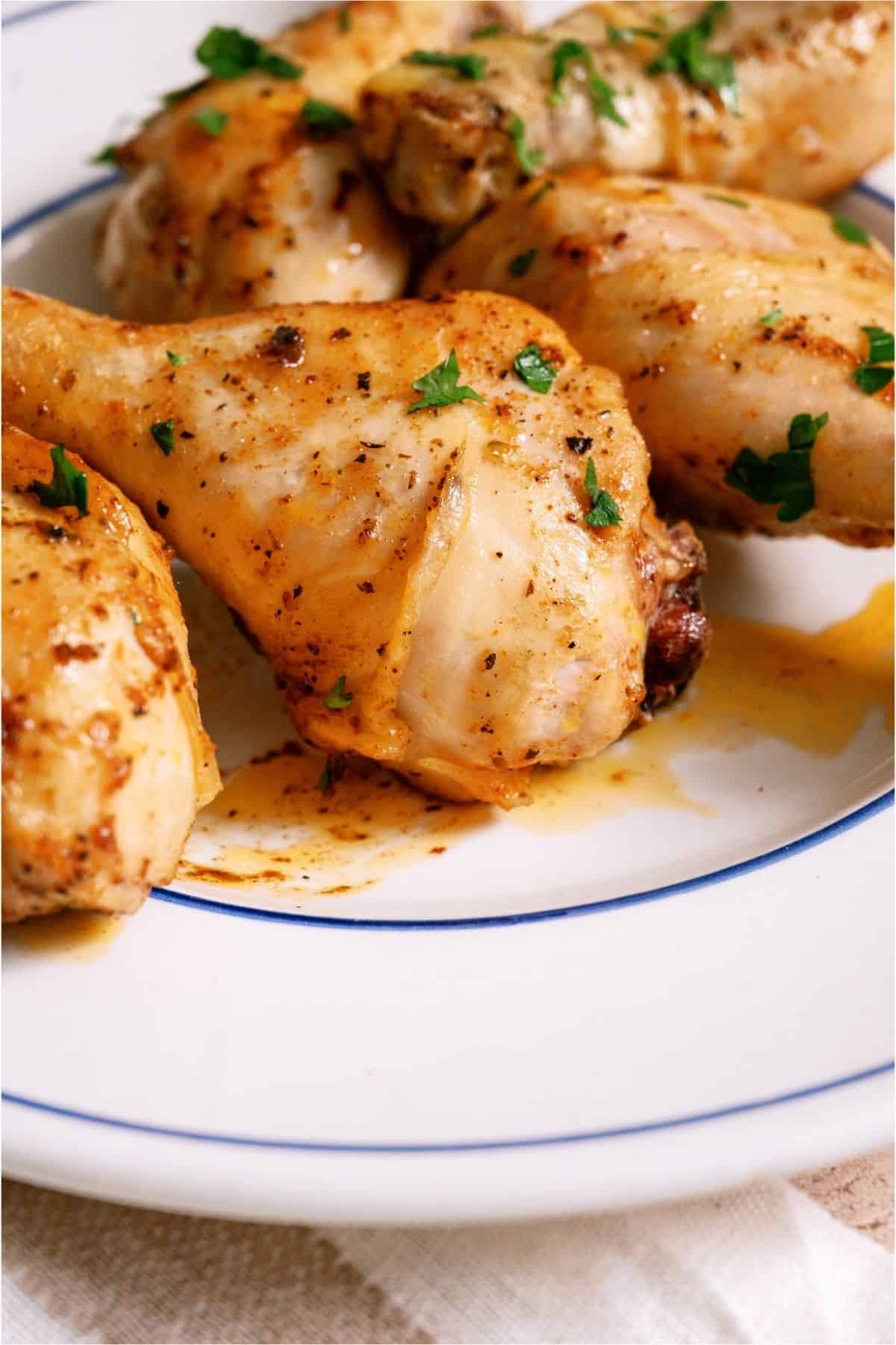 Juicy Baked Chicken Legs on a white plate.