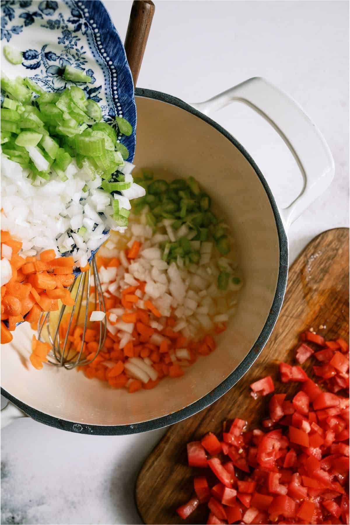 Adding chopped veggies to stock pot.