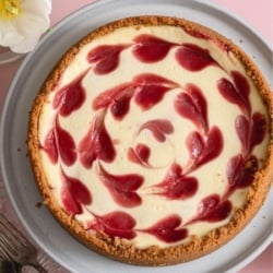 Classic Strawberry Cheesecake in a pan on a pink background.