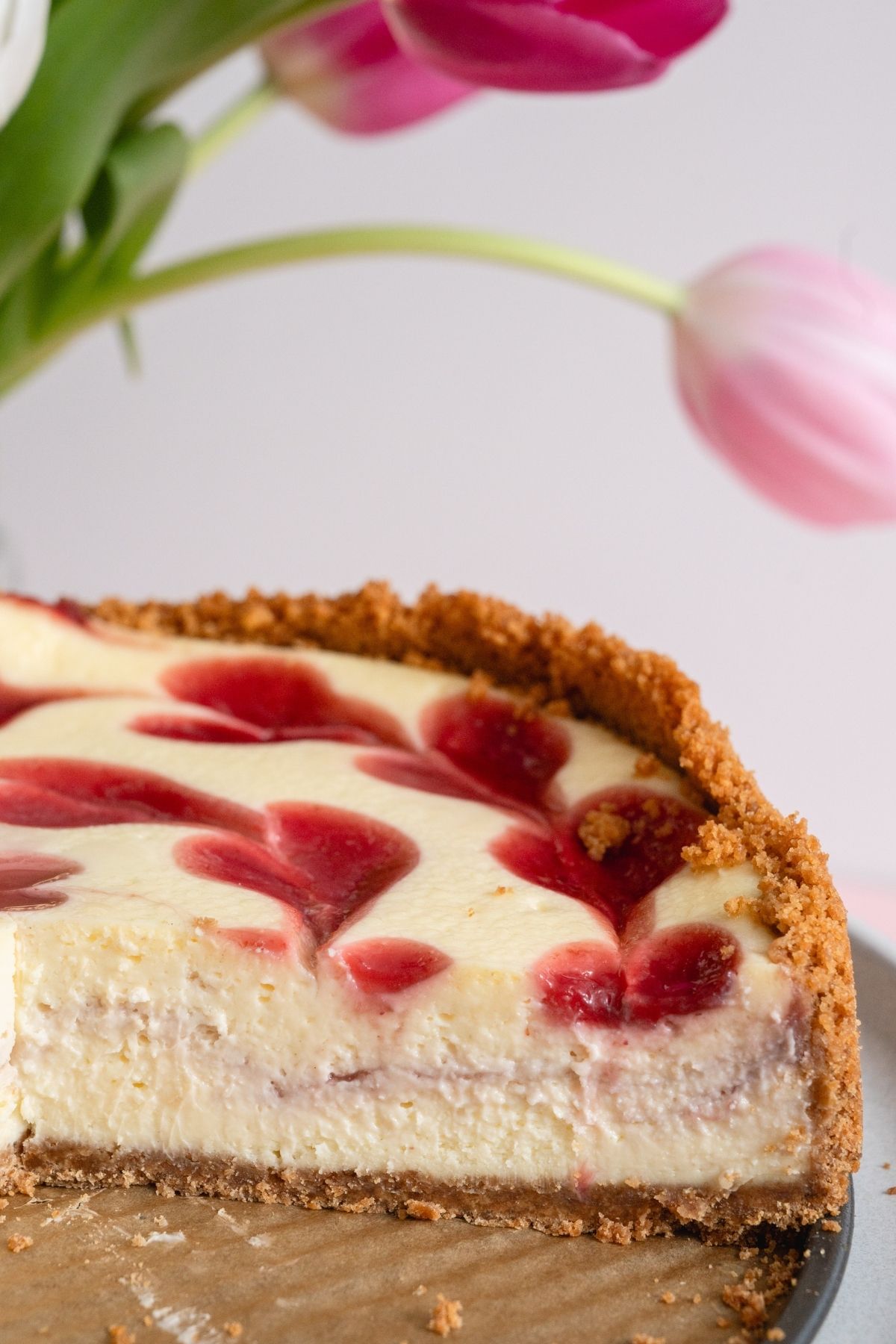 A partially sliced Classic Strawberry Cheesecake.