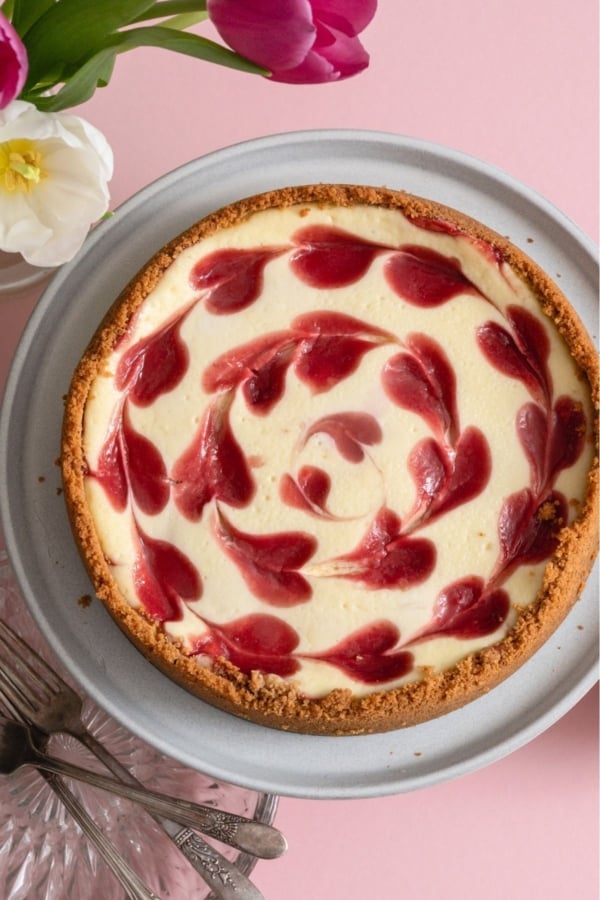 Classic Strawberry Cheesecake in a pan on a pink background.